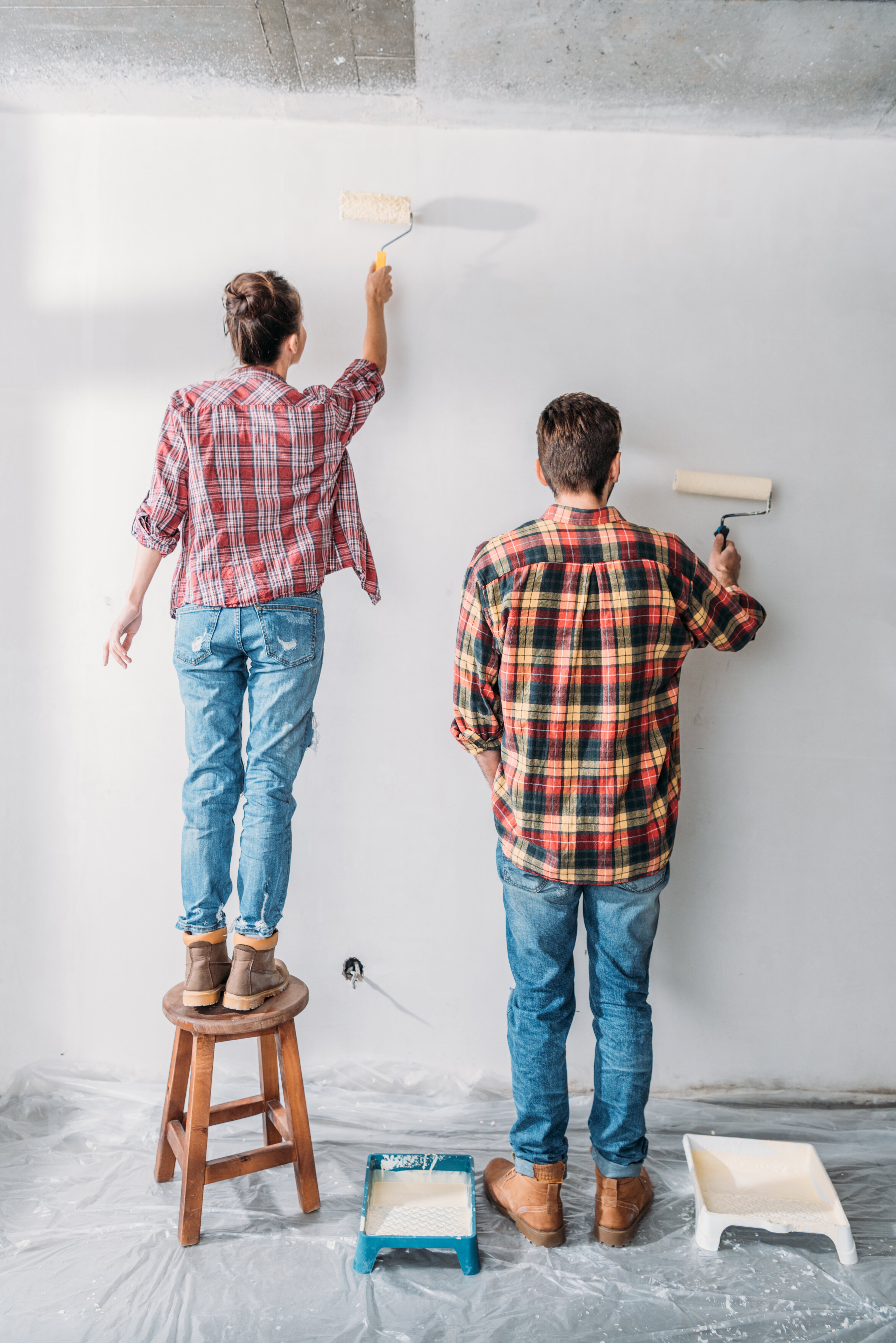 Two homeowners painting a wall
